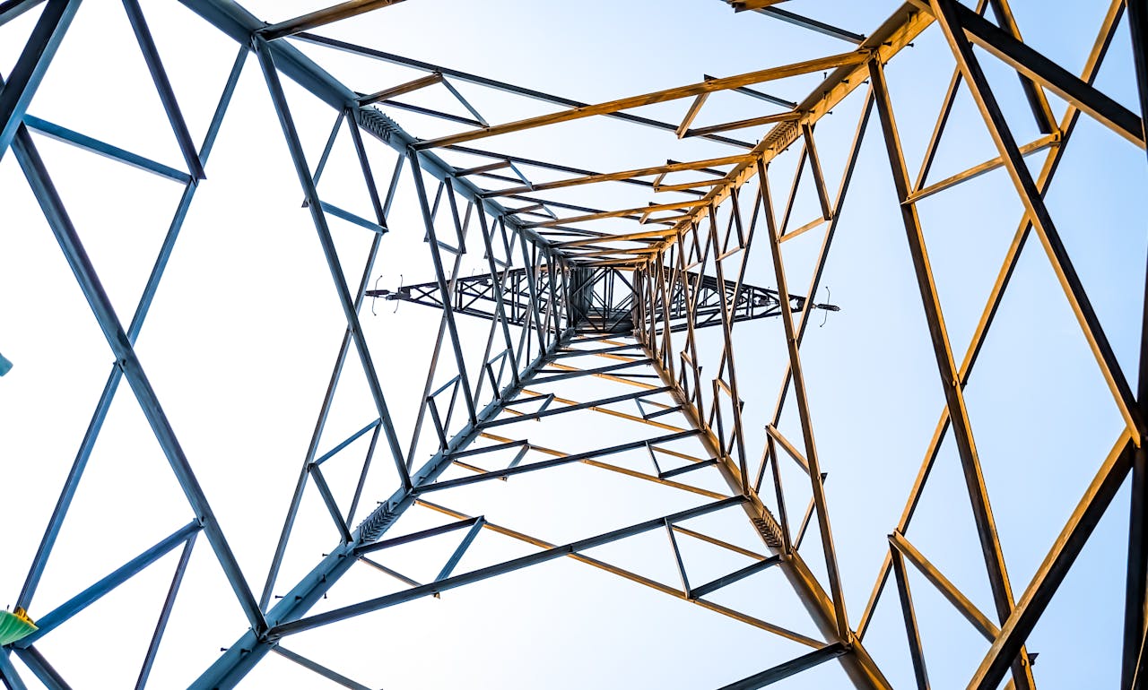 Looking up at a geometric power transmission tower in Depok, Indonesia.